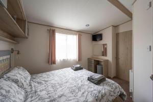 a bedroom with a bed and a window at Hallcroft Fishery And Holiday Park in Retford