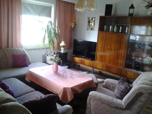 ein Wohnzimmer mit einem Tisch, Stühlen und einem TV in der Unterkunft Ferienhaus Werner 