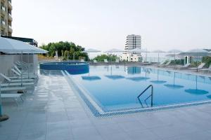 een groot zwembad met blauw water in een gebouw bij Status-M Apartments 135 in Becici +14 foto's