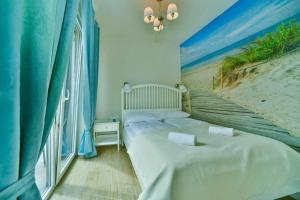 una camera con due letti e un dipinto di una spiaggia di Holiday resort, Grzybowo a Grzybowo