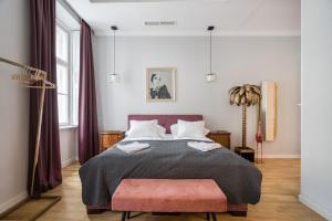 um quarto com uma cama grande e um banco rosa em BpR Adagio Design Home with A/C em Budapeste