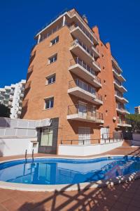 a building with a swimming pool in front of a building at APCOSTAS Villa de Madrid in Blanes