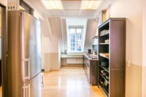 a kitchen with a refrigerator and a window at Kings Garden Penthouse - 4BR & 2Bath - by Daniel&Jacob's in Copenhagen