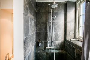a shower in a bathroom with black tiles at Kings Garden Penthouse - 4BR & 2Bath - by Daniel&Jacob's in Copenhagen
