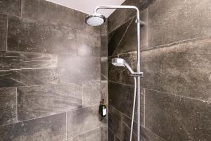 Łazienka z prysznicem wyłożona jest czarnymi kafelkami. w obiekcie Kings Garden 1 by Daniel&jacob's w Kopenhadze