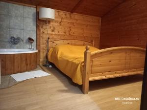 um quarto com uma cama e uma banheira em Idill Üdülőház em Tiszafüred