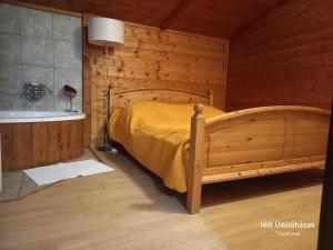1 dormitorio con cama y bañera en Idill Üdülőház, en Tiszafüred