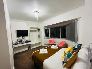 una camera d'albergo con letto e TV di ATZ&H Inn a Luton