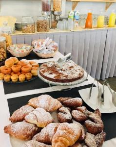 a buffet with various pastries and pies and other foods at Hotel President in Cervia