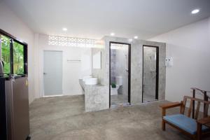 a bathroom with a shower and a sink and a mirror at Tree Home ที่พักเบตงสไตล์ครอบครัว in Ban Komo Sip Paet