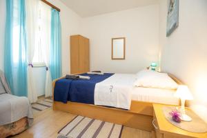 una camera da letto con un letto con una coperta blu e bianca di Apartment Brunac a Brbinj