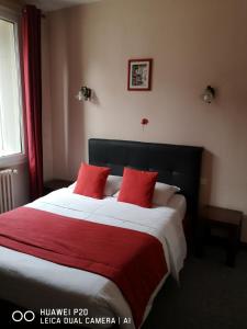 een slaapkamer met een groot bed met rode kussens bij Hôtel Le Memphis in Poitiers