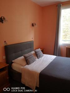 a bedroom with a bed with orange walls and a window at Hôtel Le Memphis in Poitiers