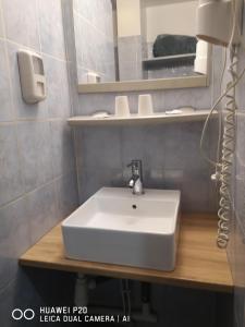 uma casa de banho com um lavatório branco e um espelho. em Hôtel Le Memphis em Poitiers