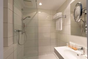 a bathroom with a shower and a sink at Wyndham Köln in Cologne