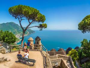 a group of people sitting on a bench looking at the ocean at Residence Le Villette in Ravello