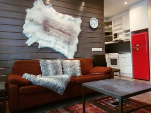 a living room with a couch and a clock on a wall at Ski Center Alpine Houses A4 in Levi
