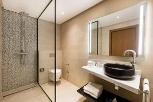 
a bathroom with a shower, sink, and toilet at Radisson Blu Hotel Casablanca City Center in Casablanca
