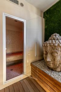 a glass shower in a room with a statue at Vistamare Suite in Lido di Savio