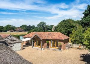 a large brick house with a roof at Little Barn at Coppice Barn, Birdham in Birdham