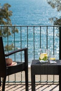 twee stoelen en een tafel met een drankje op een balkon bij Hotel Roses Platja in Roses