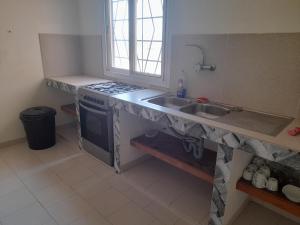 a kitchen with a sink and a stove at Appart Ziguinchor in Ziguinchor