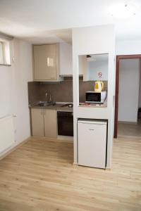Una pequeña cocina con estufa y microondas. en Apartmani Baotić Županja, en Županja