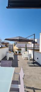 grupa białych stołów i krzeseł na dachu w obiekcie Atico en Puerta Osario w Sewilli