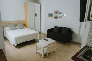 a living room with a bed and a couch and a table at Apartamentos ZHR 1 in Zahara de los Atunes