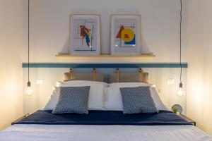 een slaapkamer met een bed met een blauw hoofdeinde bij Cool and stylish city apartment - WiFi in Trieste