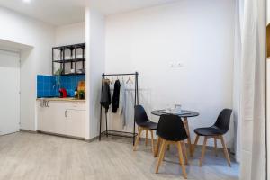 een keuken met een tafel en stoelen in een kamer bij Cool and stylish city apartment - WiFi in Trieste