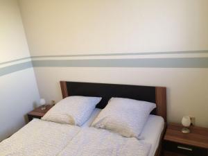 - 2 lits dans une chambre avec des rayures sur le mur dans l'établissement Ferienwohnung-Haus-luetje-wehr, à Hattstedtermarsch
