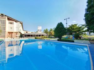 a large blue swimming pool in front of a building at Hotel Canoeiros in Pirapora