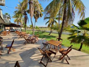 a row of tables and chairs and palm trees at Hotel Canoeiros in Pirapora