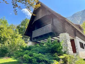a cabin with a balcony on the side of it at Red Beech Cabin - An Alpine Cabin near Lake Bohinj in Bohinj
