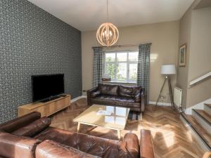 un soggiorno con mobili in pelle e TV a schermo piatto di Loughrigg View ad Ambleside