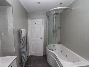 une salle de bain avec une baignoire blanche et une douche dans l'établissement Loughrigg View, à Ambleside 19 autres photos