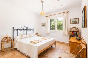a bedroom with a bed and a window at Villa Nereida in Es Migjorn Gran