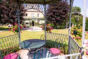 a gazebo with a table and chairs in a garden at La Ramade - Teritoria in Avranches