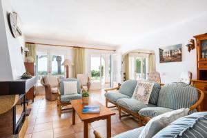 a living room with two older people sitting on couches at Villa Nereida in Es Migjorn Gran +1 photo