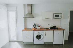 uma cozinha com uma máquina de lavar roupa e um lavatório em Apartamentos ZHR 2 em Zahara de los Atunes