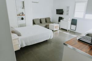 Habitación blanca con cama y escritorio en Apartamentos ZHR 2, en Zahara de los Atunes