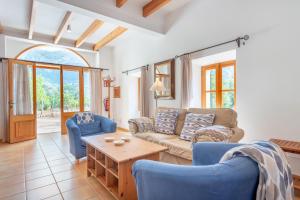 a living room with a couch and chairs and a table at Deià semi-detached sunny country house, near GR221 in Deia
