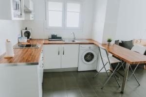 a kitchen with a washing machine and a wooden table at Apartamentos ZHR 2 in Zahara de los Atunes