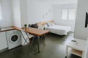a room with a bed and a table and a washing machine at Apartamentos ZHR 2 in Zahara de los Atunes