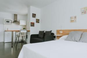 a bedroom with a bed and a couch and a table at Apartamentos ZHR 2 in Zahara de los Atunes
