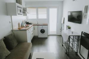 a kitchen with a washing machine in a white kitchen at Apartamentos ZHR 2 in Zahara de los Atunes