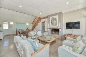 a living room with white furniture and a fireplace at Colours of the Sea - Main house in Struisbaai