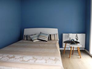 a bedroom with a bed with a blue wall at I due carrubi in Custonaci