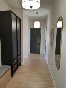 a hallway with a black door and a mirror at Apartament Zoja in Elblag